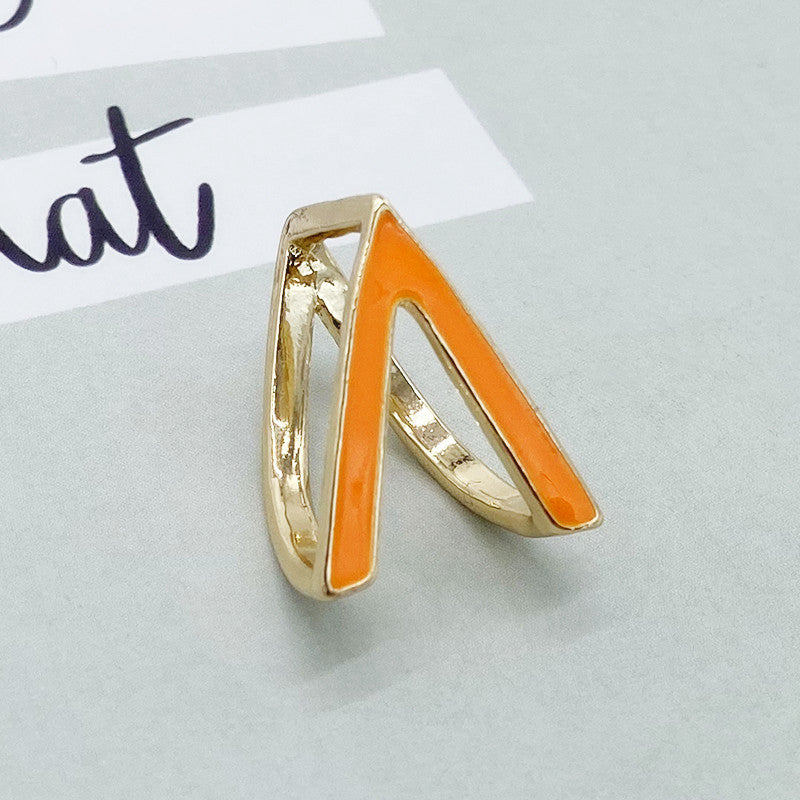 Gold ring with orange accent on a light gray background