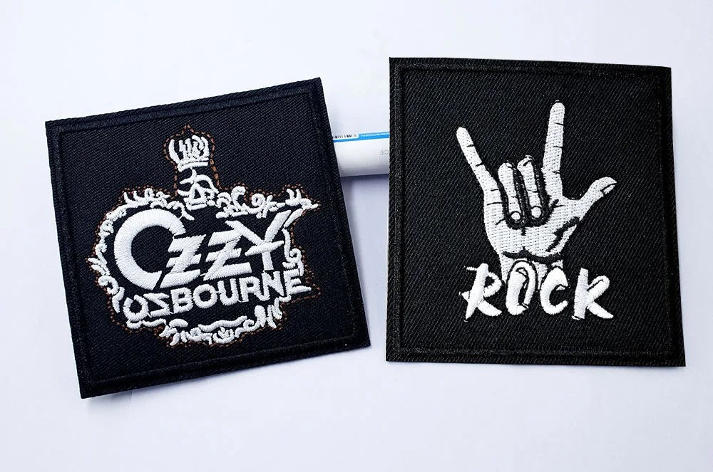 Two embroidered patches on a white background, one with &
