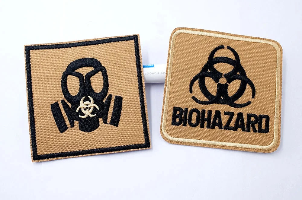 Two patches with gas mask and biohazard symbols on beige backgrounds.