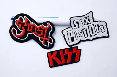 Three band logos: Ghost, Sex Pistols, and Kiss, on a white background.
