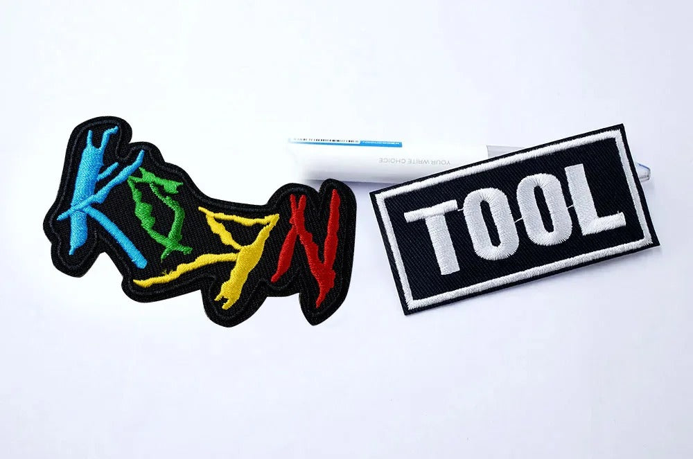 Colorful 'Korn' logo patch and 'Tool' text patch on a white background