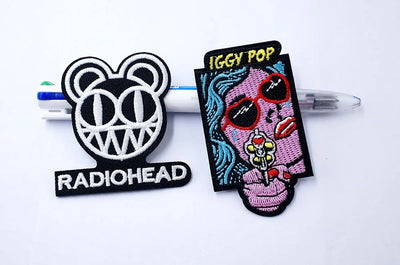 Two patches, one with Radiohead logo and the other with Iggy Pop design, on a white background.