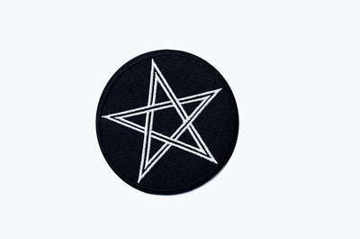 Black circular patch with a white star design on a white background