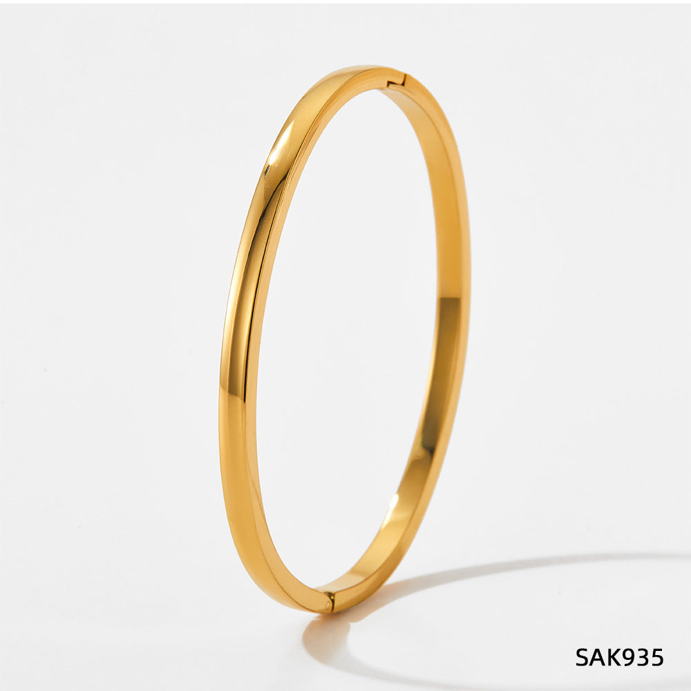 Gold bangle on a light gray background