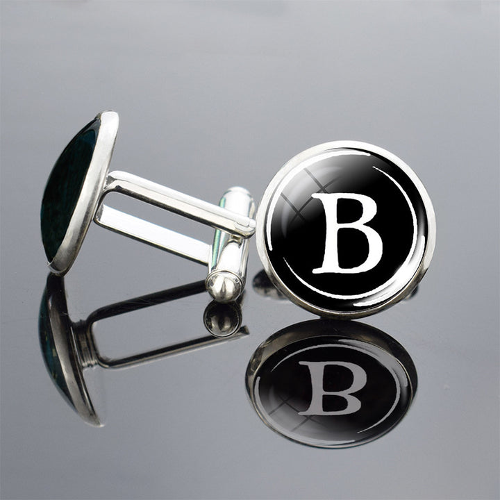 Cufflinks with a black round emblem featuring the letter &
