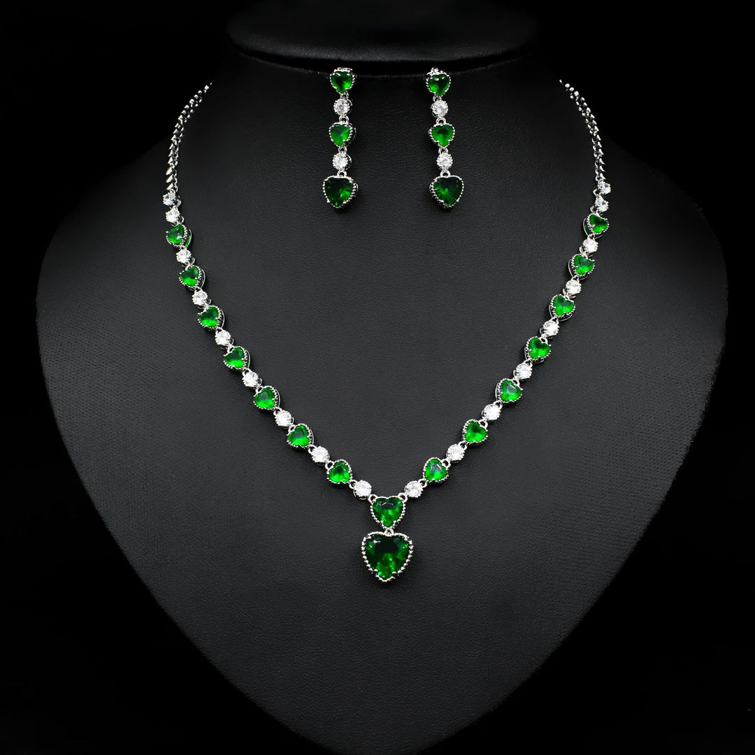 Jewelry set with necklace and earrings featuring green and clear stones on a black background