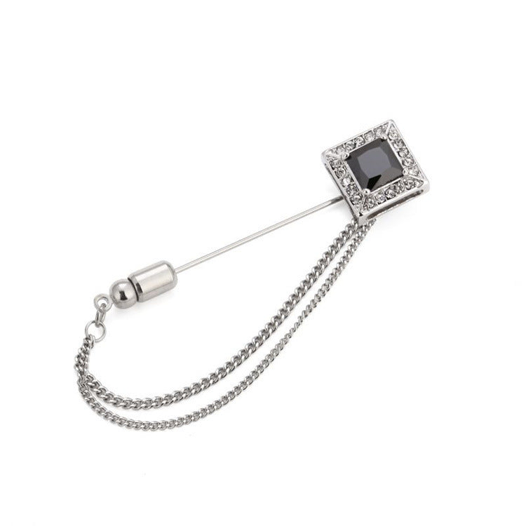 Silver brooch with a chain on a white background