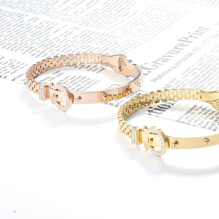 Two gold bracelets on a newspaper background