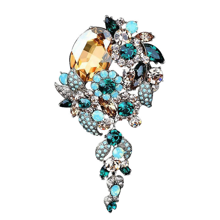 Decorative brooch with multicolored gemstones on a white background