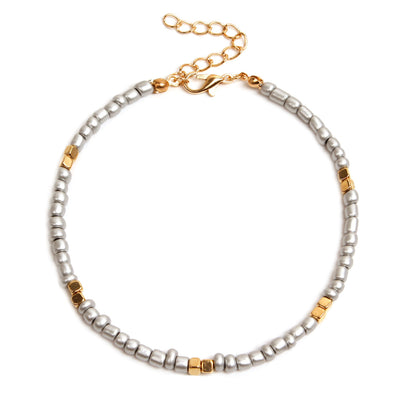 Anklet with silver and gold beads on a white background