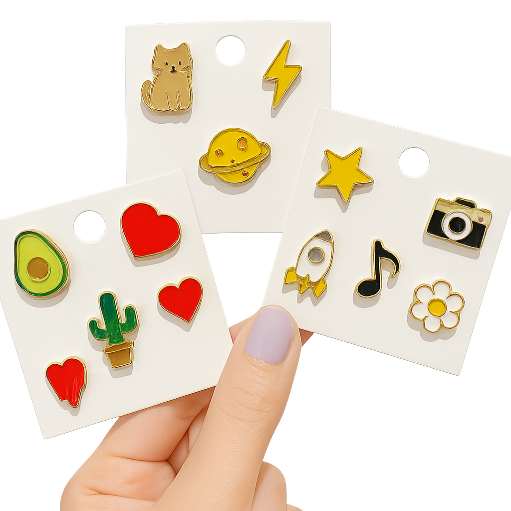 Set of colorful enamel pins on display cards held by a hand.