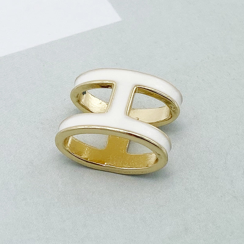Gold and white ring on a light gray background