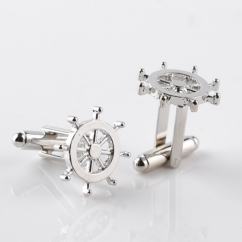 Silver ship wheel cufflinks on a light gray background