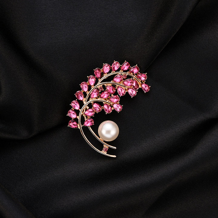 Brooch with pink gemstones and a pearl on black fabric