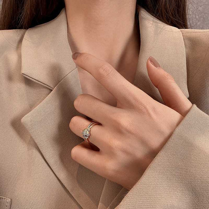 Close-up of a hand wearing a ring with a green gemstone against a beige background