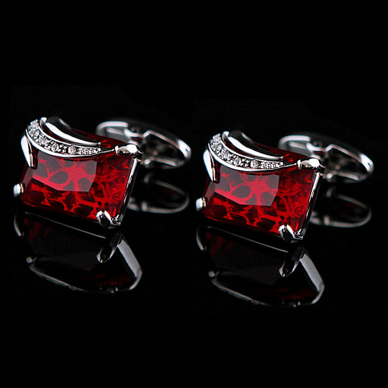 Red gemstone cufflinks with silver accents on a black background