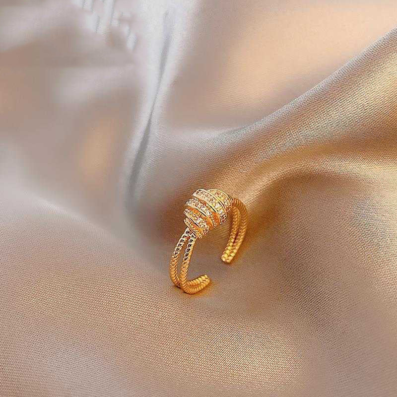 Gold ring with gemstones on a soft fabric background