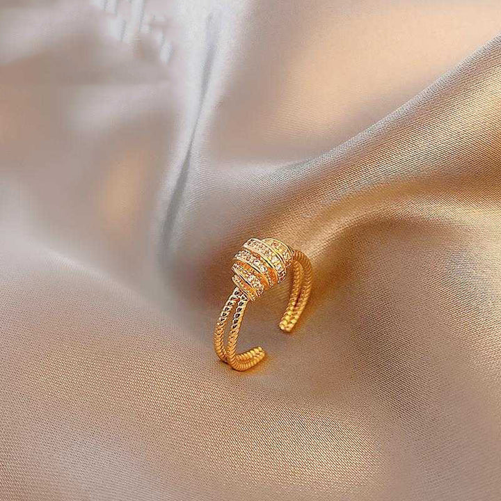 Gold ring with gemstones on a soft fabric background