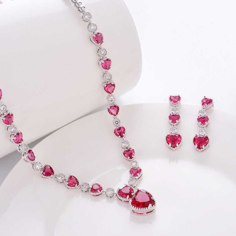 Jewelry set with pink heart-shaped gemstones on a white background