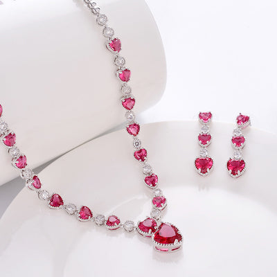 Jewelry set with pink heart-shaped gemstones on a white background