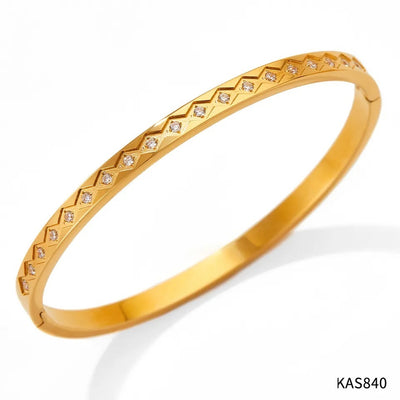 Gold bracelet with diamond-like stones on a white background