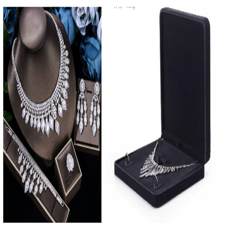 Silver jewelry set including necklace, earrings, and brooch in display cases.