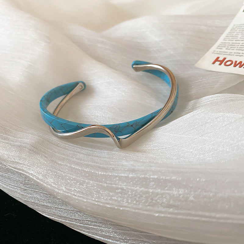 Blue and silver bracelet on a white fabric background