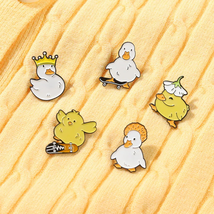 Set of cartoon duck pins on a wooden surface