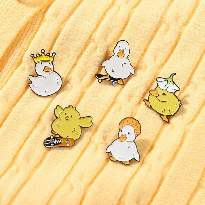 Set of cartoon duck pins on a wooden surface