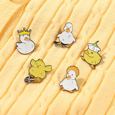 Set of cartoon duck pins on a wooden surface