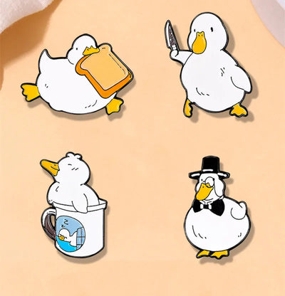 Set of four cartoon duck pins on a beige background