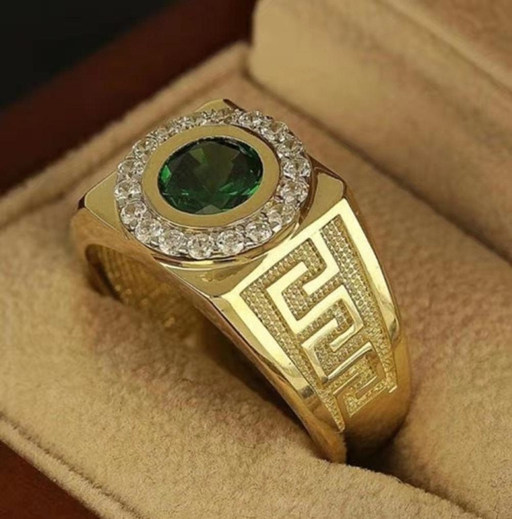 Gold statement ring with green gemstone on velvet background