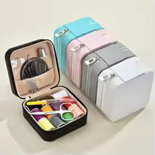 Set of colorful sewing kits with open case on a light background