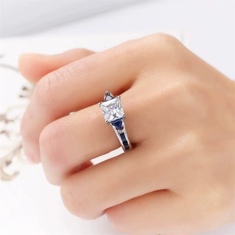 Close-up of a hand wearing a zircon ring on a white background