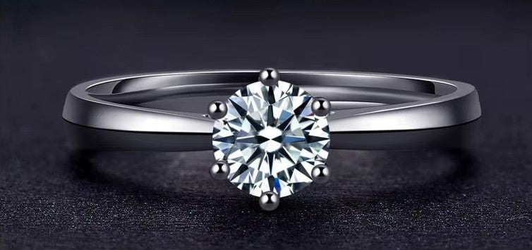 Silver ring with a diamond on a dark background