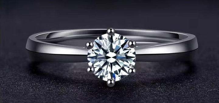 Silver ring with a diamond on a dark background
