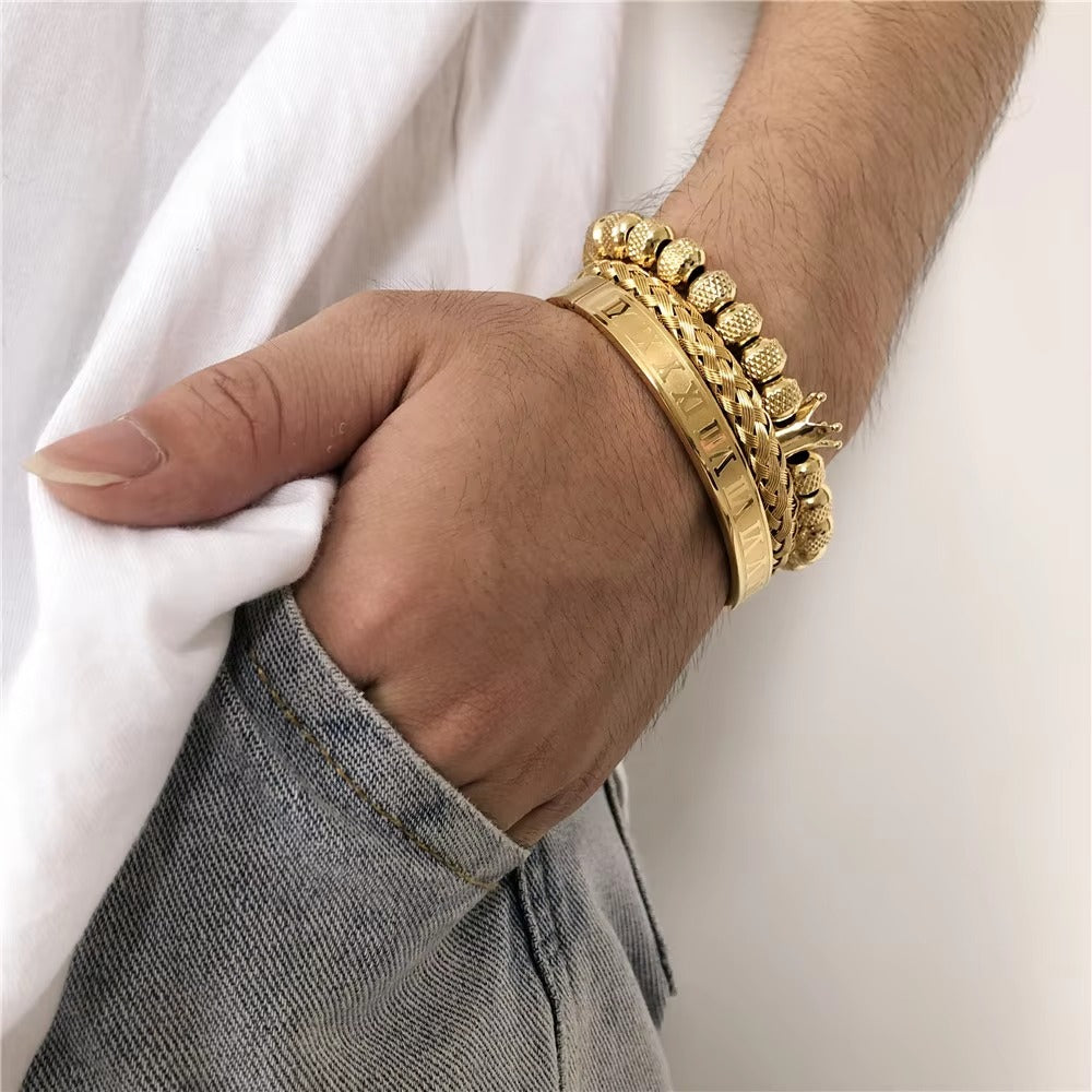 Hand wearing a gold bracelet with a blurred background