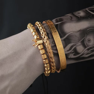 Gold bracelets on a wrist with a dark background
