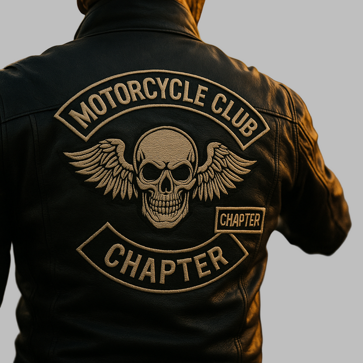 Person wearing a leather jacket with a motorcycle club chapter emblem on a motorcycle.