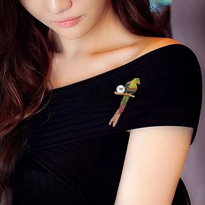 a woman wearing a natural and simple bird brooch on a black dress