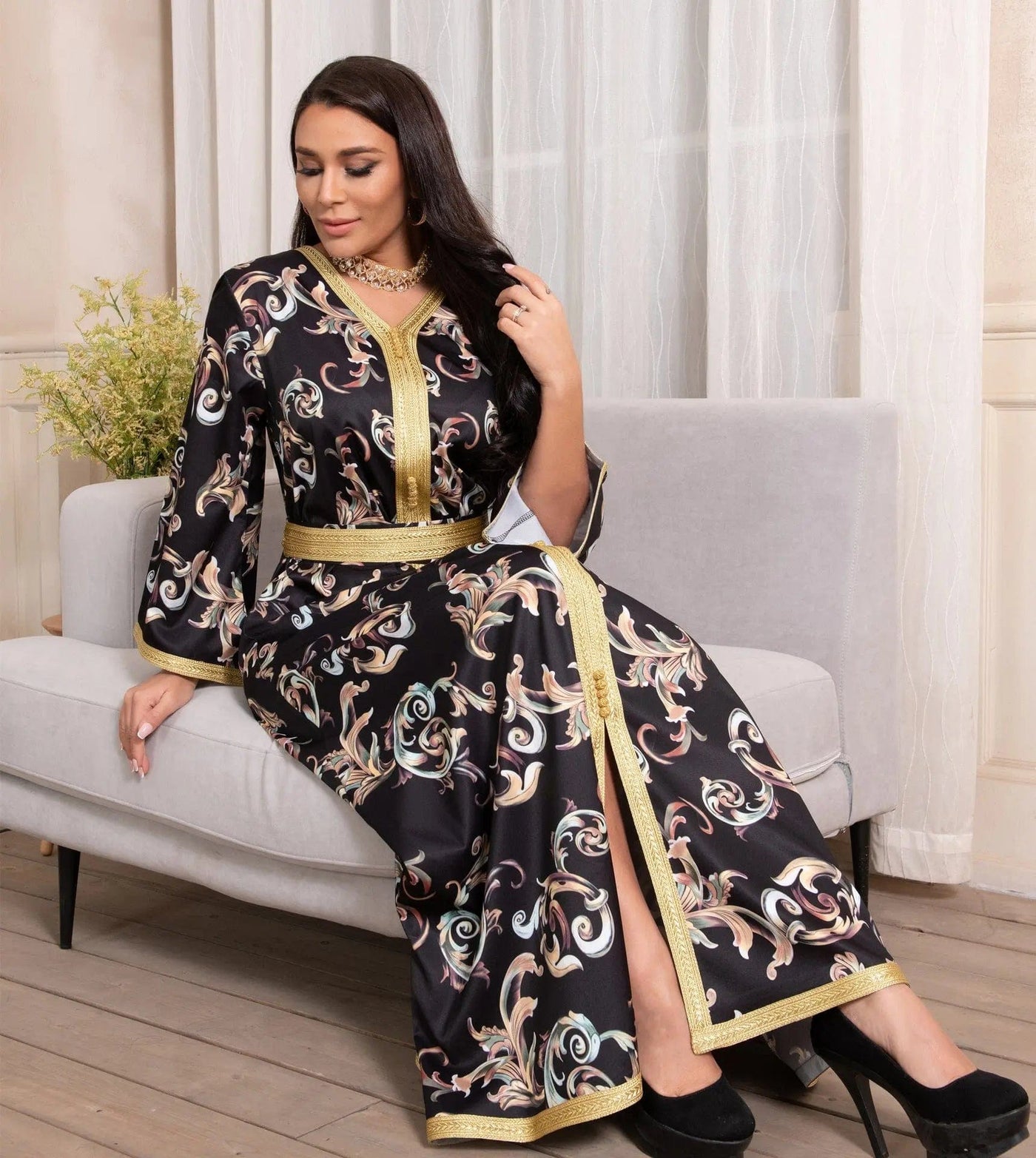 a woman wearing new dubai printed long belt dress full length view sitting on a couch