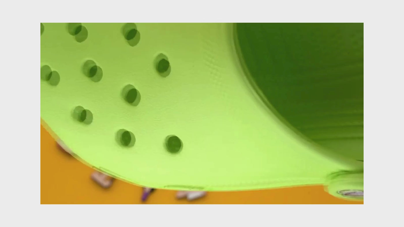 Video of a Colorful shoe charms on a green shoe with a bright yellow background