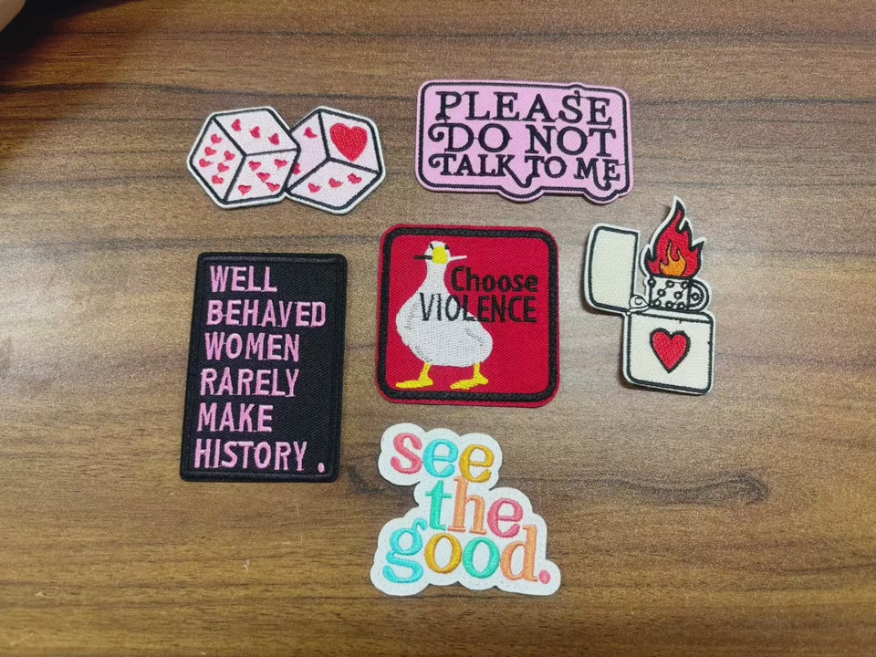 video of a Collection of various patches with text and graphics on a wooden background