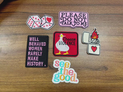 video of a Collection of various patches with text and graphics on a wooden background