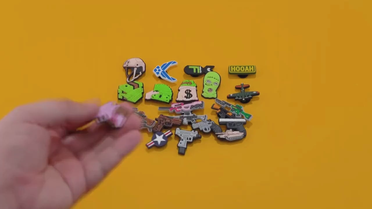 Video of a Collection of sports-themed and gaming-themed shoe charms on a yellow background