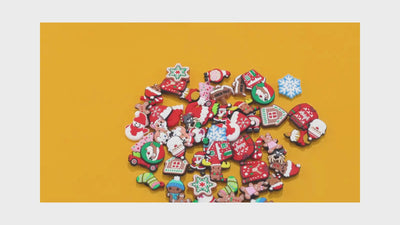 video of a Collection of colorful Christmas-themed shoe charms on a yellow background