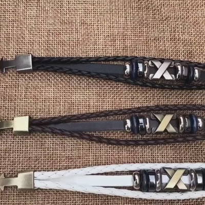 video of Three braided leather bracelets with metal clasps on a textured surface