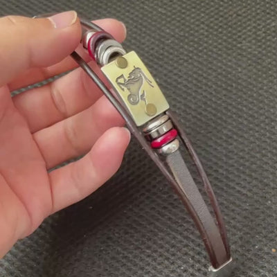 video illustrating Bracelet with leather strap, metal tag, and circular elements on a white background