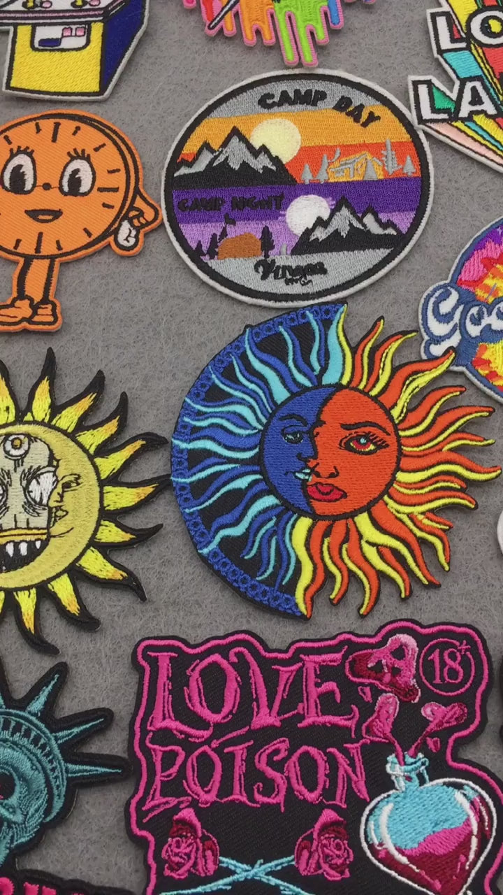 video of Cartoon and slogan embroidered patches – rainbow, heart, dino, sun, quotes and skull designs on grey background