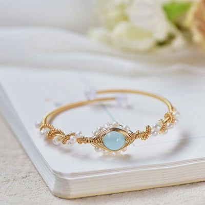 video of a central view of a Gold bracelet with a blue gemstone in different positions and view 